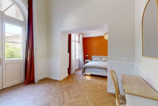 une chambre avec mur orange dans la maison SENIORYTA de Niort